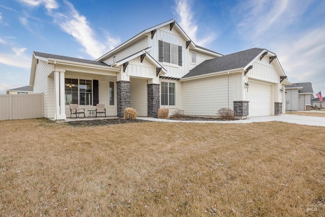 craftsman house with a front yard, a garage, board and batten siding, and driveway