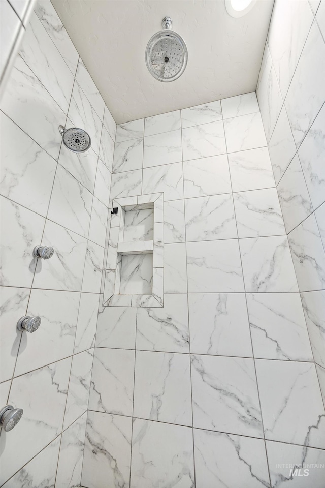 full bath featuring tiled shower