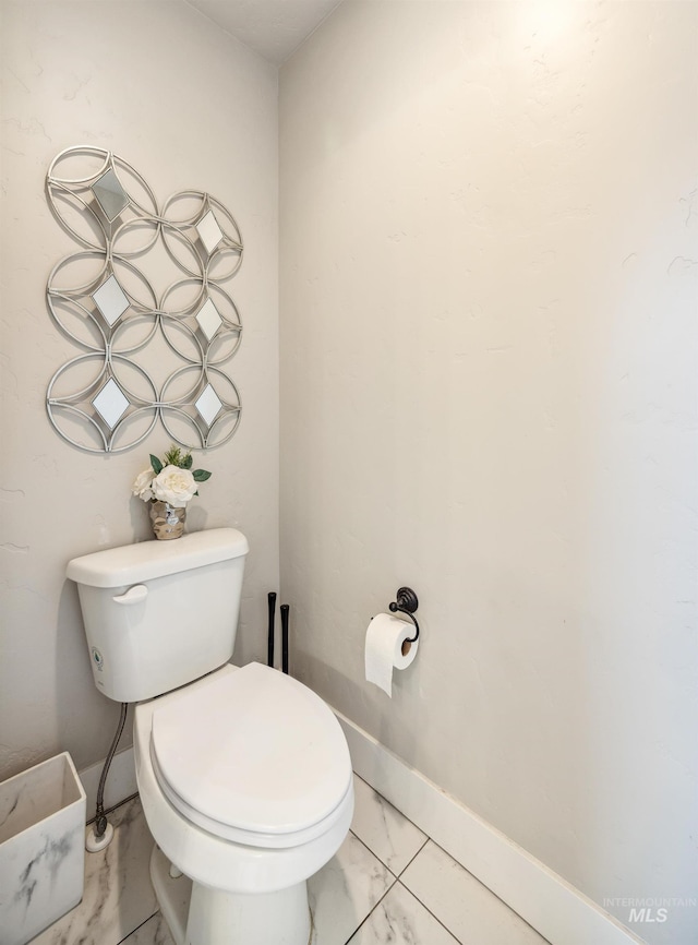 bathroom featuring baseboards, toilet, and marble finish floor