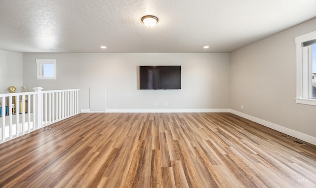 empty room with visible vents, baseboards, recessed lighting, wood finished floors, and a textured ceiling