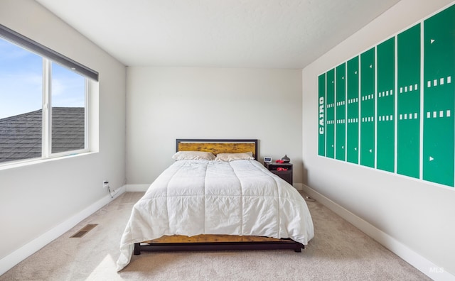 carpeted bedroom featuring visible vents and baseboards