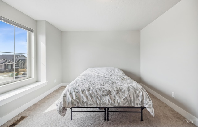 bedroom with visible vents, carpet flooring, and baseboards