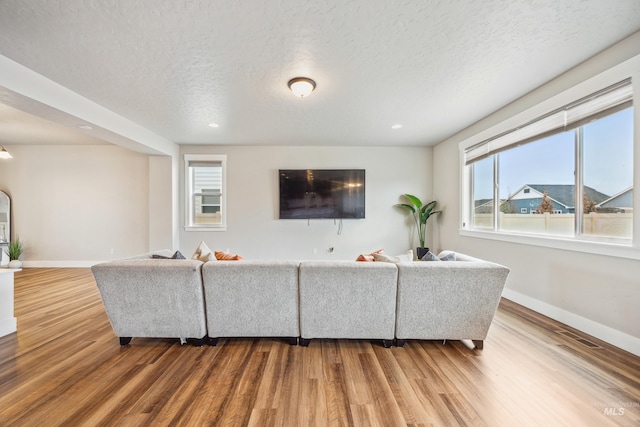 living area with visible vents, baseboards, and wood finished floors