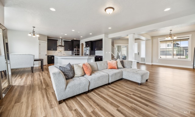 living area featuring a notable chandelier, recessed lighting, and light wood-type flooring