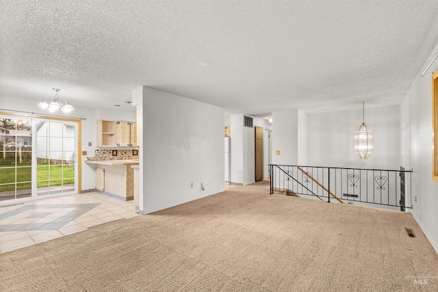 unfurnished living room with light colored carpet, a textured ceiling, and a chandelier