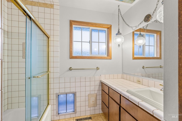 bathroom with vanity, tile patterned floors, plenty of natural light, and enclosed tub / shower combo