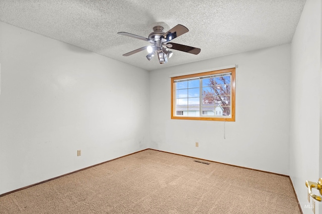 empty room with a textured ceiling, carpet floors, and ceiling fan