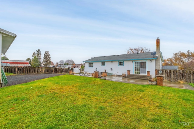 rear view of property featuring a yard and a patio