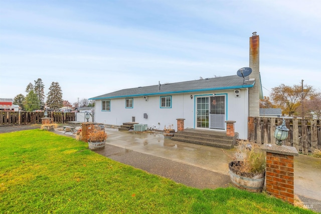 rear view of property featuring a patio, central AC, and a lawn