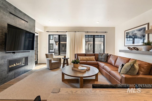 carpeted living room featuring a tiled fireplace