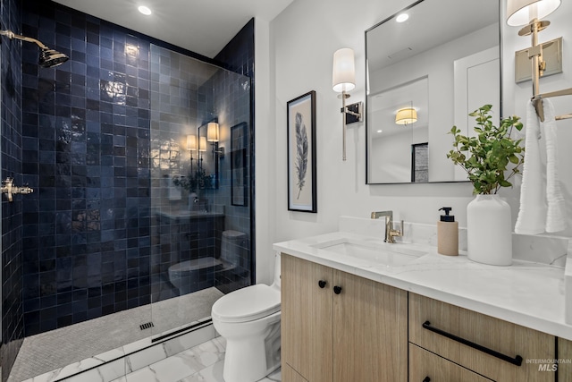 bathroom featuring tiled shower, vanity, and toilet