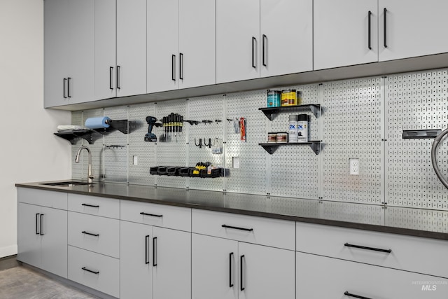 interior space with white cabinetry, sink, and light hardwood / wood-style flooring