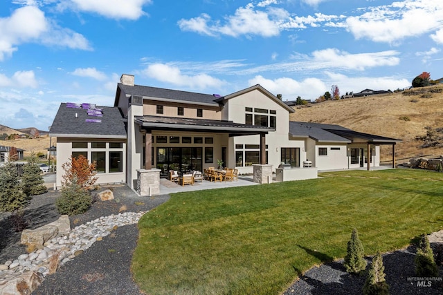 back of house featuring a patio and a yard