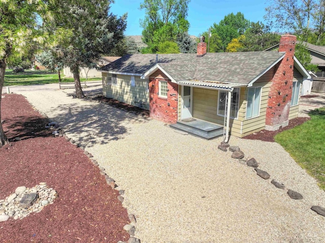 2912 S Harmony Ave, Boise, ID 83706 - view of front facade with a chimney, a shingled roof, brick siding, and driveway
