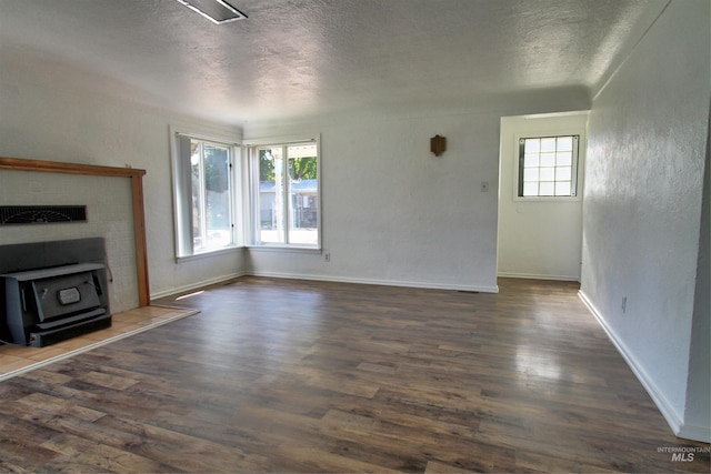 2912 S Harmony Ave, Boise, ID 83706 - unfurnished living room with a wood stove, a textured ceiling, dark wood-style flooring, and baseboards