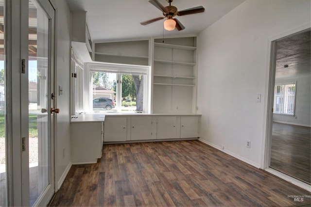 2912 S Harmony Ave, Boise, ID 83706 - unfurnished dining area featuring a ceiling fan, dark wood-type flooring, vaulted ceiling, baseboards, and built in shelves