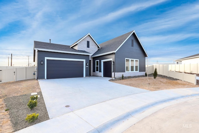 view of front of house featuring fence, a gate, a shingled roof, concrete driveway, and an attached garage