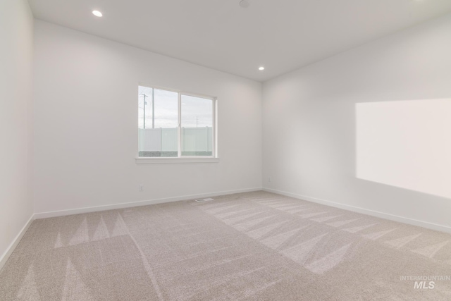 empty room with baseboards, carpet, and recessed lighting