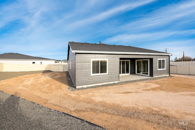 rear view of property featuring a patio and a fenced backyard