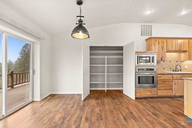 kitchen with sink, decorative light fixtures, dark wood-type flooring, and stainless steel appliances