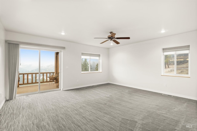 unfurnished room with ceiling fan and carpet