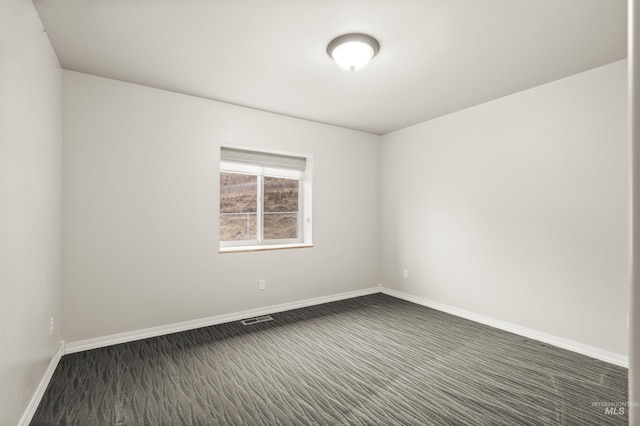 unfurnished room featuring dark carpet