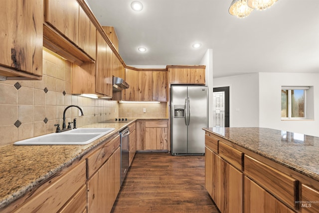 kitchen with tasteful backsplash, sink, stainless steel appliances, and stone countertops