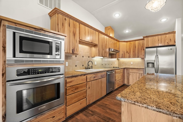 kitchen with sink, backsplash, dark hardwood / wood-style flooring, light stone counters, and stainless steel appliances