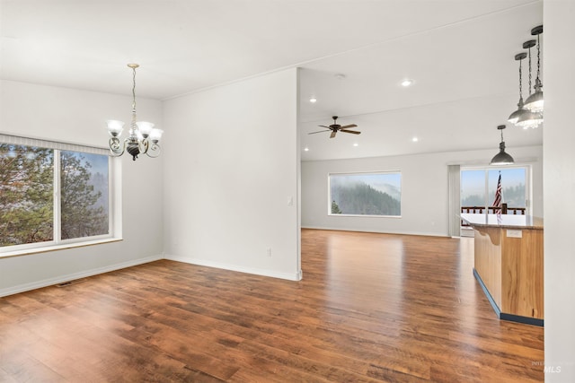 interior space with ceiling fan with notable chandelier and dark hardwood / wood-style flooring