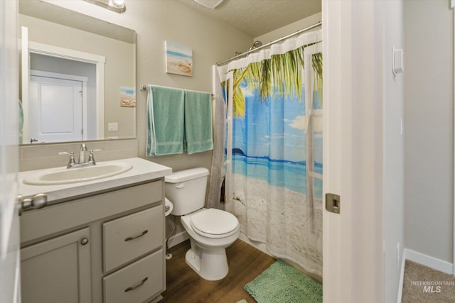 bathroom featuring hardwood / wood-style floors, curtained shower, vanity, toilet, and a textured ceiling