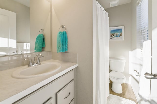 bathroom featuring hardwood / wood-style floors, tasteful backsplash, vanity, a shower with curtain, and toilet