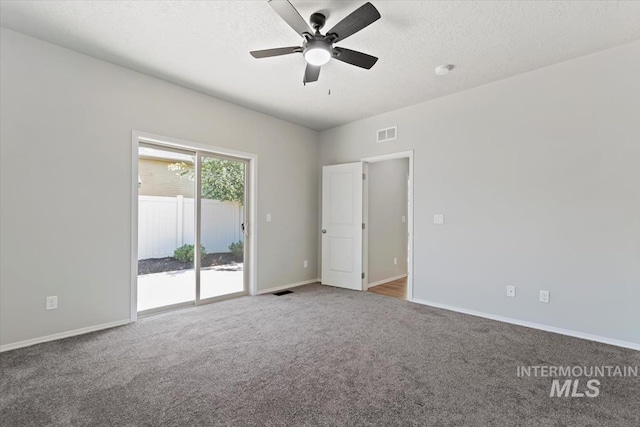 carpeted empty room with ceiling fan, baseboards, and a textured ceiling