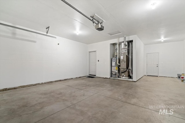garage with a garage door opener, gas water heater, and heating unit