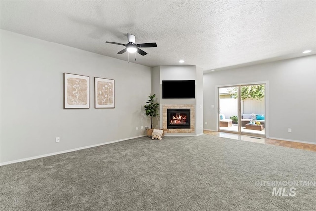 unfurnished living room featuring a fireplace, a textured ceiling, a ceiling fan, recessed lighting, and baseboards