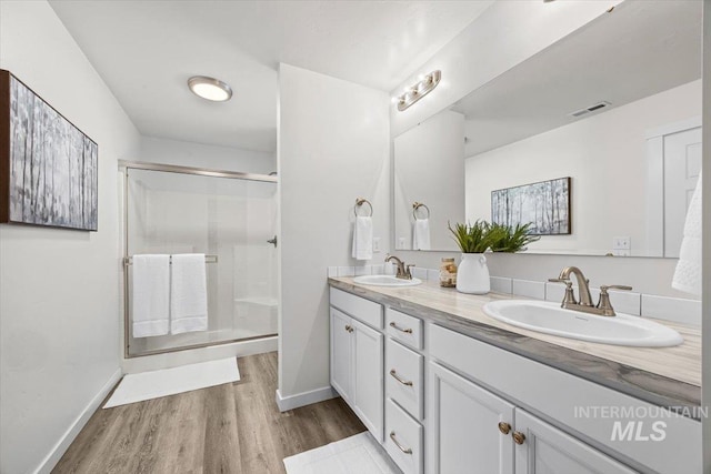 655 N Sevenoaks Ave, Eagle, ID 83616 - full bathroom featuring double vanity, a stall shower, wood finished floors, and baseboards