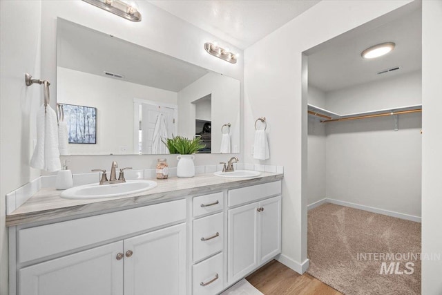655 N Sevenoaks Ave, Eagle, ID 83616 - bathroom with double vanity, a walk in closet, baseboards, and wood finished floors