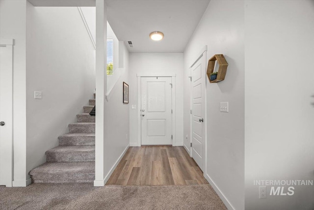 655 N Sevenoaks Ave, Eagle, ID 83616 - carpeted foyer entrance featuring stairs, baseboards, and wood finished floors