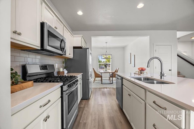 655 N Sevenoaks Ave, Eagle, ID 83616 - kitchen with stainless steel appliances, a sink, wood finished floors, light countertops, and white cabinets