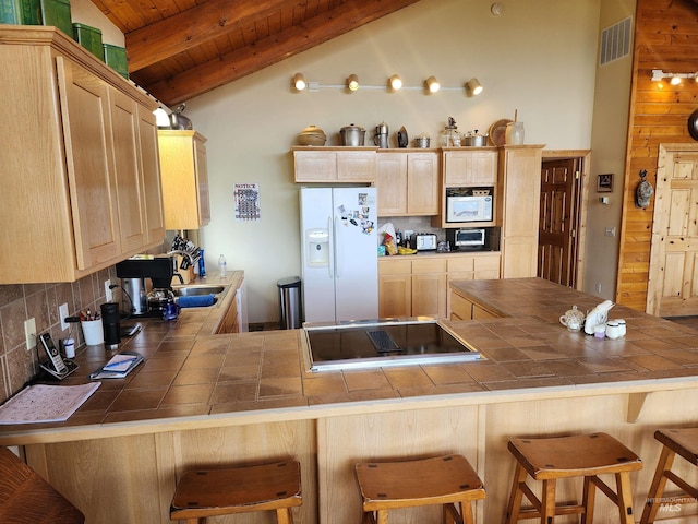 kitchen with white appliances, tile countertops, light brown cabinetry, and backsplash