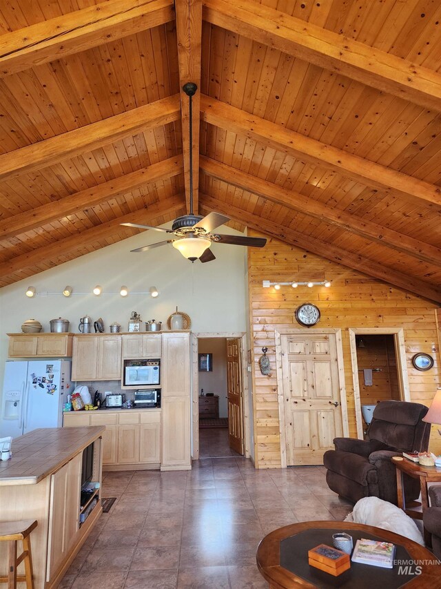 living area featuring beamed ceiling, wooden walls, high vaulted ceiling, wooden ceiling, and a ceiling fan