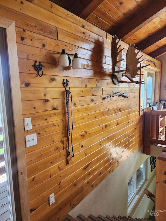 stairs with wood walls, wood ceiling, and beam ceiling