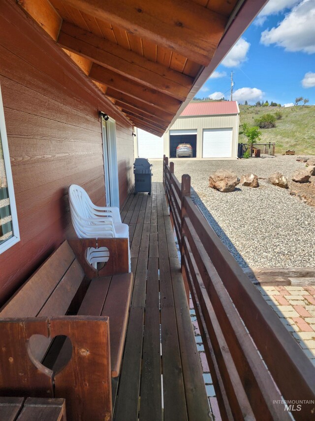 wooden terrace with an outbuilding and a grill