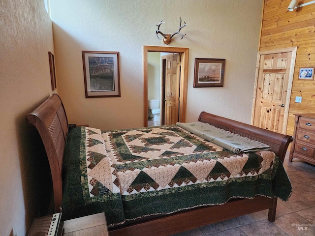 bedroom featuring wooden walls