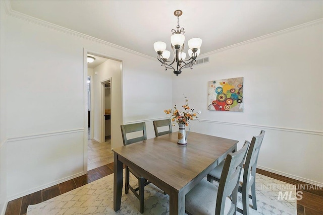 9874 W Whirlaway Ct, Boise, ID 83704 - dining area featuring a chandelier, ornamental molding, baseboards, and dark wood-style flooring