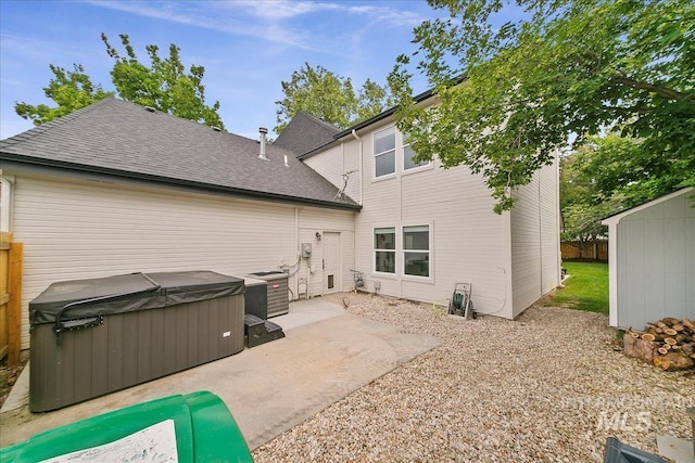 9874 W Whirlaway Ct, Boise, ID 83704 - rear view of house featuring a hot tub, a patio, central AC unit, and a shingled roof