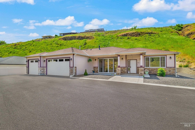 60 Appleford Ct, Asotin, WA 99402 - view of front of house with an attached garage, stone siding, and asphalt driveway