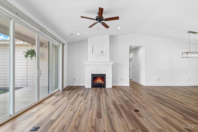 60 Appleford Ct, Asotin, WA 99402 - unfurnished living room with a stone fireplace, wood finished floors, ceiling fan, vaulted ceiling, and baseboards