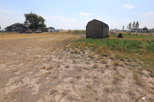 view of yard featuring a rural view and a shed