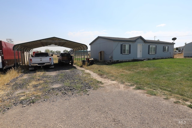 view of front of house featuring a front lawn, dirt driveway, and a detached carport