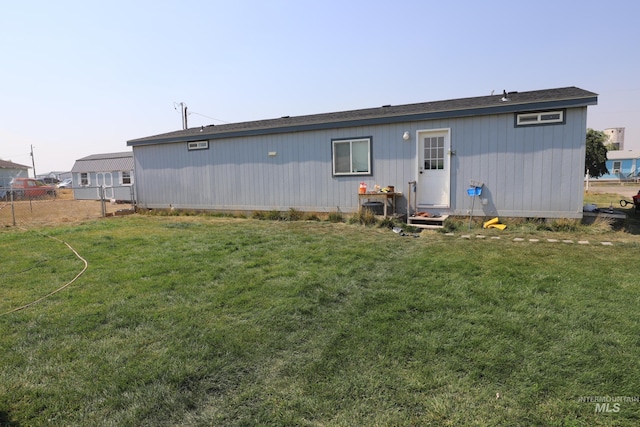 rear view of property featuring a lawn